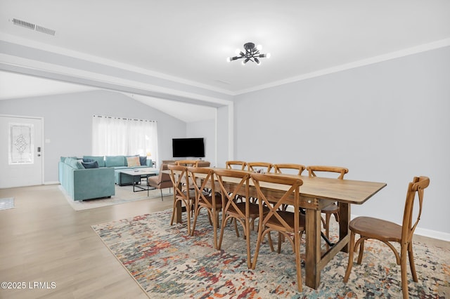 dining area featuring visible vents, baseboards, lofted ceiling, and light wood-type flooring