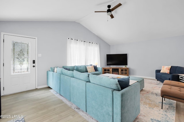 living room with a ceiling fan, light wood-type flooring, plenty of natural light, and vaulted ceiling