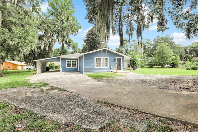 ranch-style house featuring a front yard, driveway, and a carport