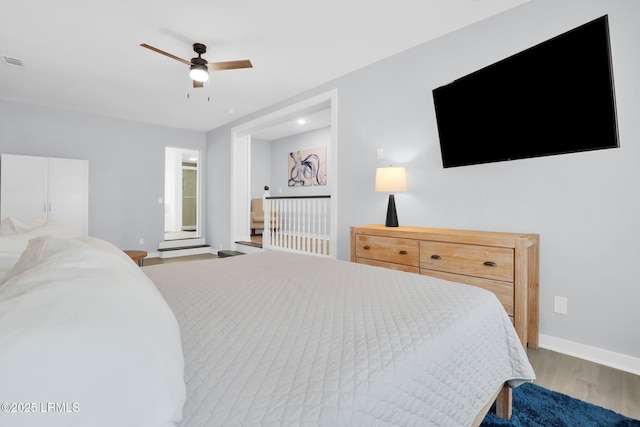 bedroom featuring visible vents, ceiling fan, wood finished floors, and baseboards