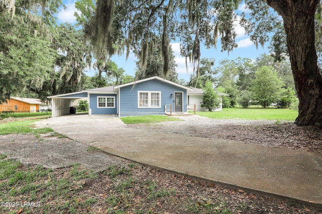 single story home with driveway, a carport, and a front lawn