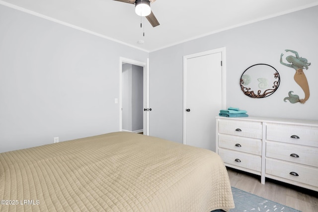 bedroom with crown molding, a ceiling fan, and wood finished floors