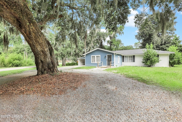 ranch-style house with driveway and a front lawn