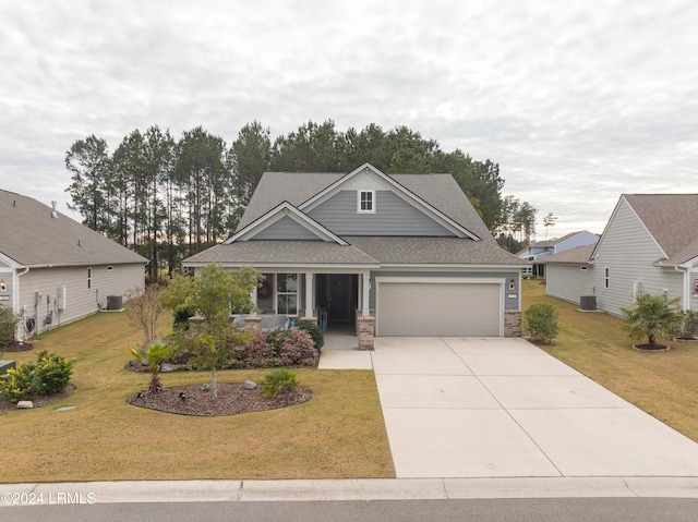 view of front of home with a garage, a front yard, and central air condition unit