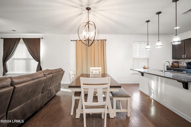 dining area with an inviting chandelier, plenty of natural light, dark hardwood / wood-style floors, and sink