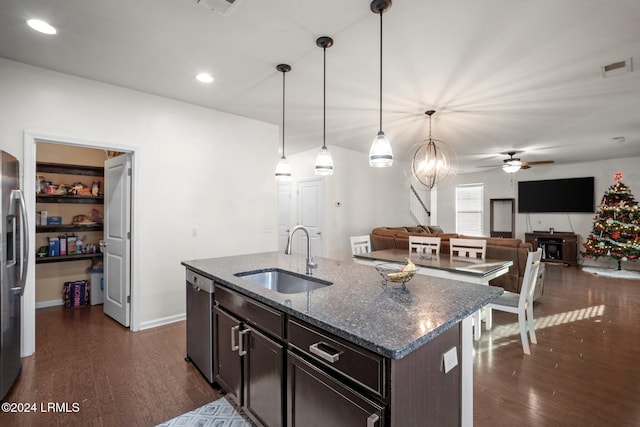 kitchen with sink, hanging light fixtures, stainless steel appliances, dark brown cabinetry, and dark stone counters