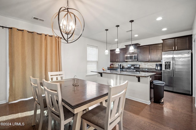 dining space featuring an inviting chandelier, dark hardwood / wood-style floors, and sink