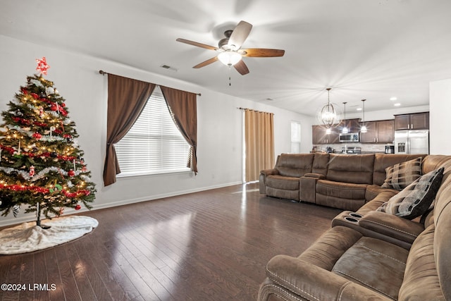 living room with dark hardwood / wood-style floors and ceiling fan with notable chandelier