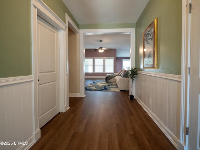 hallway with dark wood-style floors and wainscoting