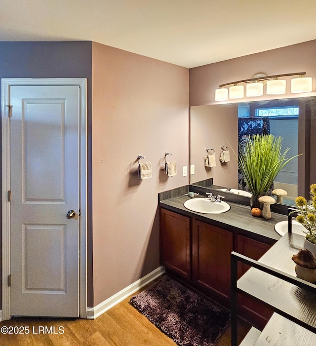 bathroom featuring vanity, baseboards, and wood finished floors