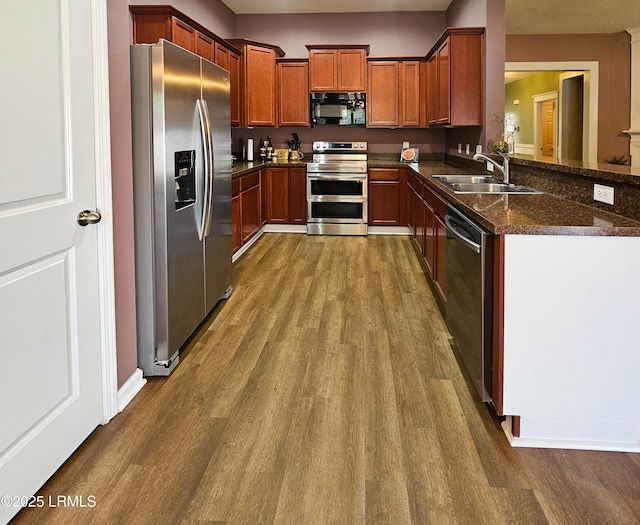 kitchen featuring stainless steel appliances, dark wood-style flooring, and a sink