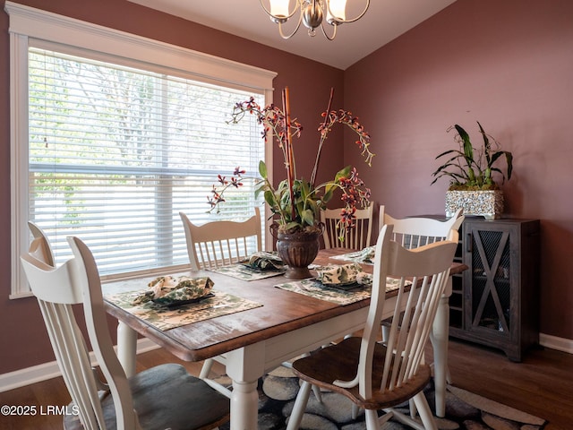 dining room with baseboards, an inviting chandelier, and wood finished floors