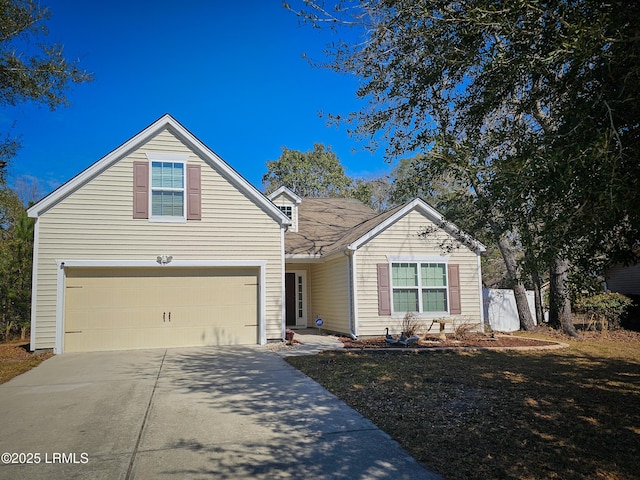 traditional home featuring a garage, concrete driveway, and fence