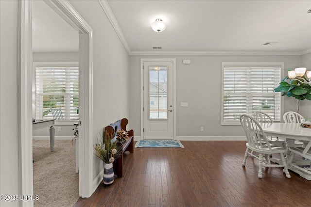 entrance foyer with visible vents, wood finished floors, baseboards, and ornamental molding