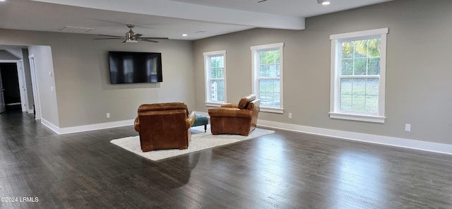 living area featuring dark wood-type flooring and ceiling fan