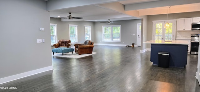 living room featuring dark wood-type flooring and ceiling fan