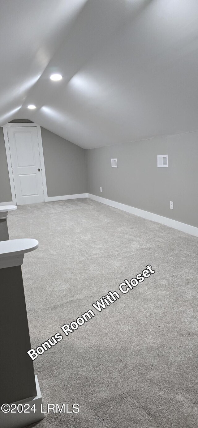 bonus room featuring lofted ceiling and carpet floors