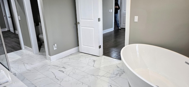 bathroom featuring a bathtub and toilet