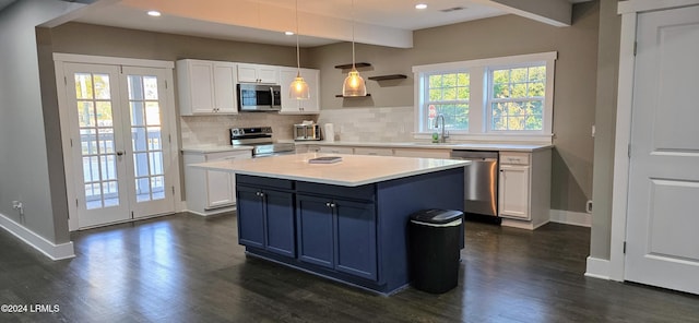 kitchen with sink, white cabinetry, hanging light fixtures, stainless steel appliances, and decorative backsplash