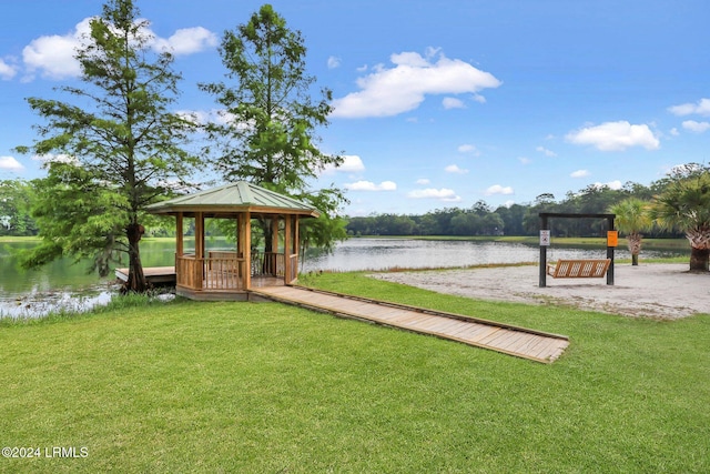 view of dock with a gazebo, a water view, and a yard