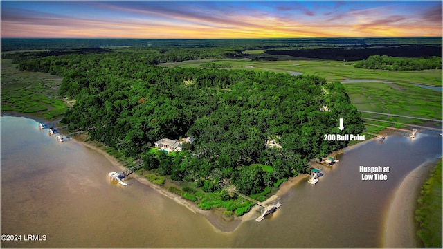 aerial view at dusk featuring a water view