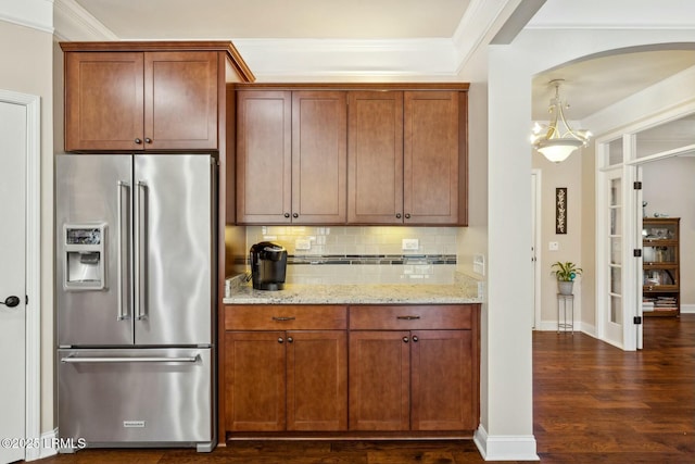 kitchen featuring tasteful backsplash, dark wood-style floors, high quality fridge, crown molding, and light stone countertops