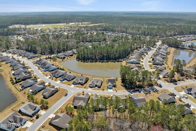 birds eye view of property with a residential view, a view of trees, and a water view