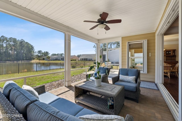 exterior space with an outdoor living space, a water view, a ceiling fan, and fence