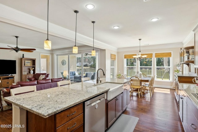 kitchen featuring dark wood-type flooring, ornamental molding, an island with sink, a sink, and dishwasher