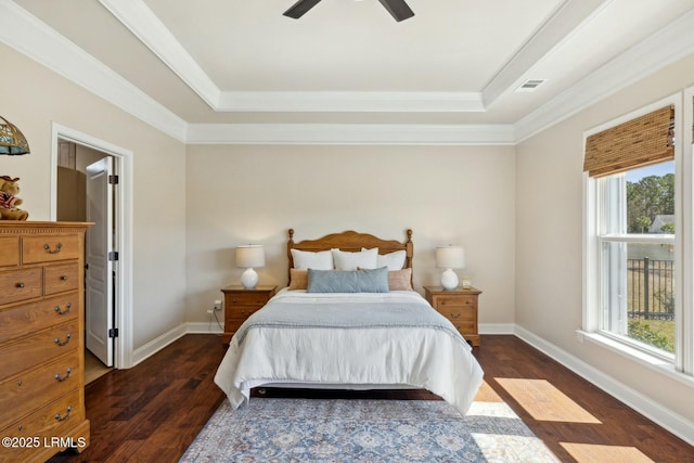 bedroom with a raised ceiling, multiple windows, dark wood-style floors, and baseboards