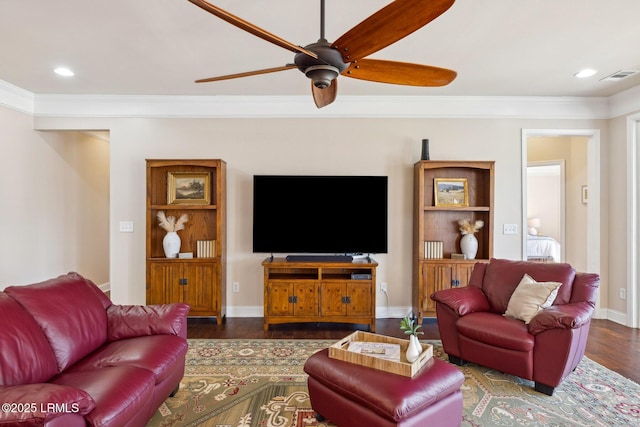 living area with visible vents, crown molding, baseboards, and wood finished floors