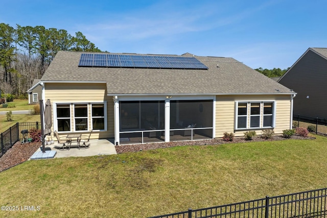 rear view of property featuring a shingled roof, a fenced backyard, a yard, a sunroom, and a patio area