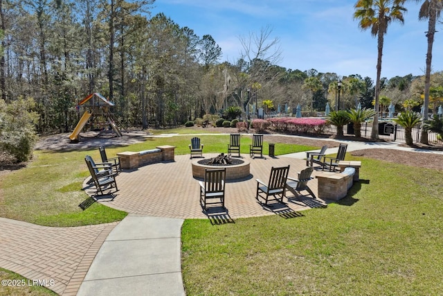 view of home's community featuring playground community, a patio, a fire pit, and a lawn