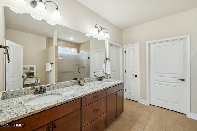 bathroom with tile patterned floors, double vanity, a stall shower, and a sink