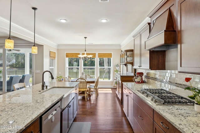 kitchen featuring premium range hood, a sink, decorative backsplash, ornamental molding, and stainless steel appliances