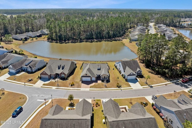 birds eye view of property with a forest view, a water view, and a residential view