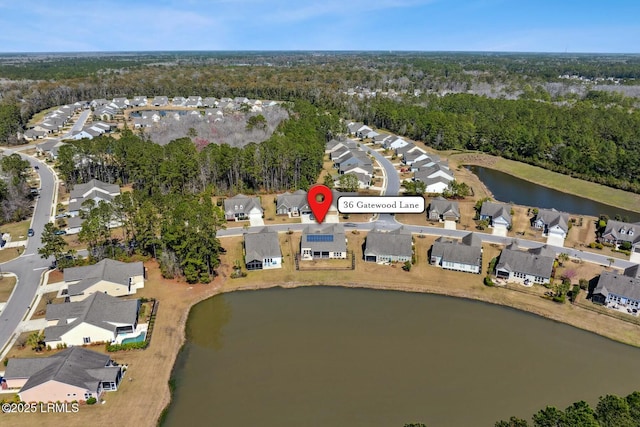 aerial view with a residential view, a wooded view, and a water view