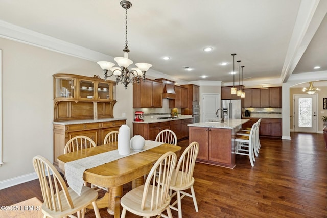 dining area with baseboards, dark wood-type flooring, a chandelier, and ornamental molding