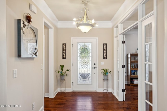 entryway with a chandelier, wood-type flooring, baseboards, and ornamental molding