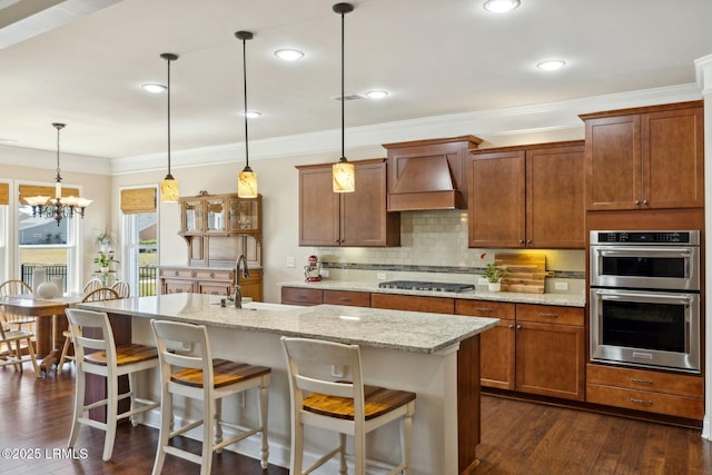 kitchen featuring premium range hood, dark wood finished floors, a sink, appliances with stainless steel finishes, and tasteful backsplash