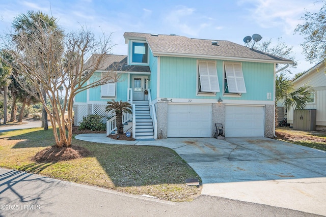 view of front of house featuring a garage, roof with shingles, and driveway