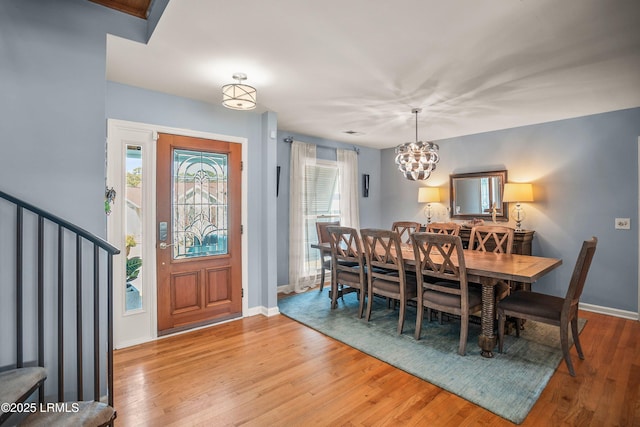 dining area with stairs, baseboards, and wood finished floors