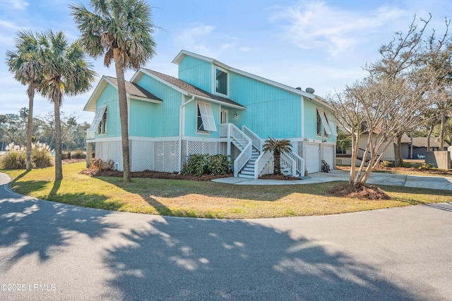 view of front of house with an attached garage, stairs, a front lawn, and concrete driveway