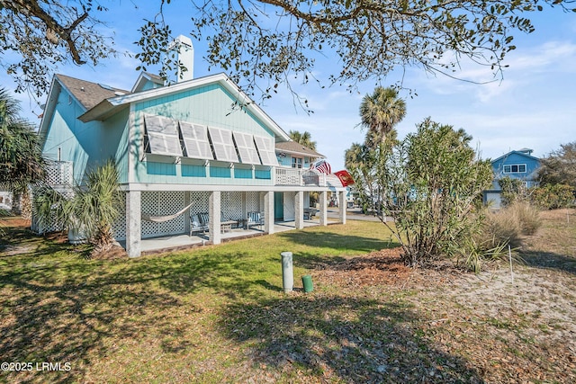 back of house with a yard, a patio area, and a balcony