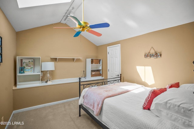 bedroom with lofted ceiling with skylight, carpet, baseboards, and track lighting