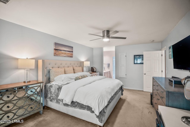 bedroom featuring baseboards, connected bathroom, a ceiling fan, and light colored carpet