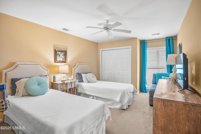bedroom with ceiling fan, visible vents, a closet, and light colored carpet