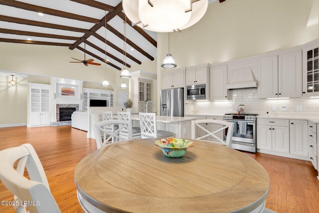 222 Hampton Lake Dr, Bluffton, SC 29910 - dining space featuring ceiling fan, beam ceiling, a brick fireplace, high vaulted ceiling, and light wood-type flooring