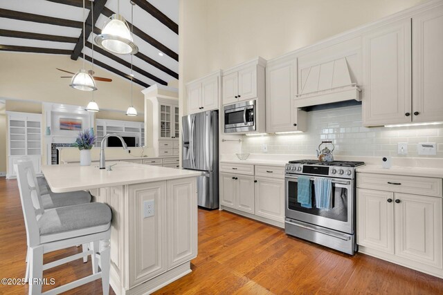 222 Hampton Lake Dr, Bluffton, SC 29910 - kitchen featuring appliances with stainless steel finishes, a kitchen breakfast bar, white cabinetry, vaulted ceiling with beams, and backsplash