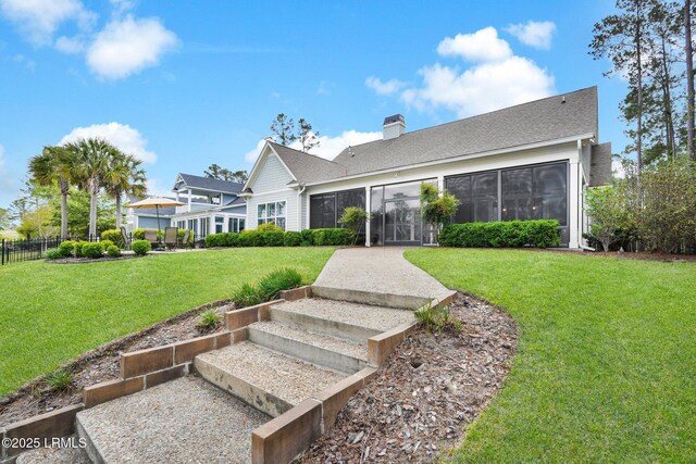 222 Hampton Lake Dr, Bluffton, SC 29910 - rear view of property with fence, a chimney, a sunroom, a shingled roof, and a yard